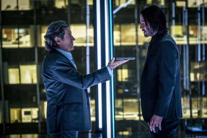 John Wick and Winston with a pistol