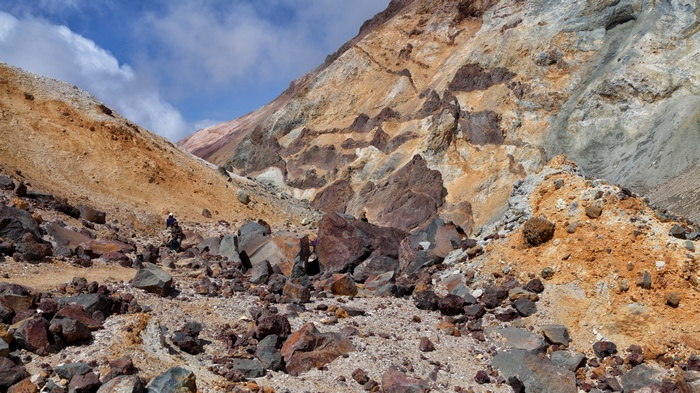 Hikers in a rocky, colorful mountain landscape