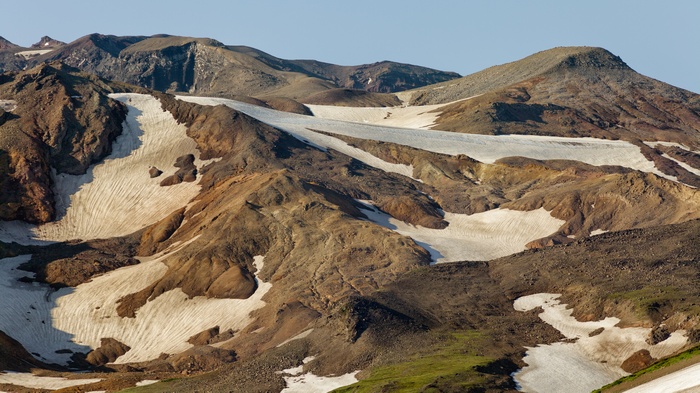 Snow-covered volcanic mountains under a clear sky