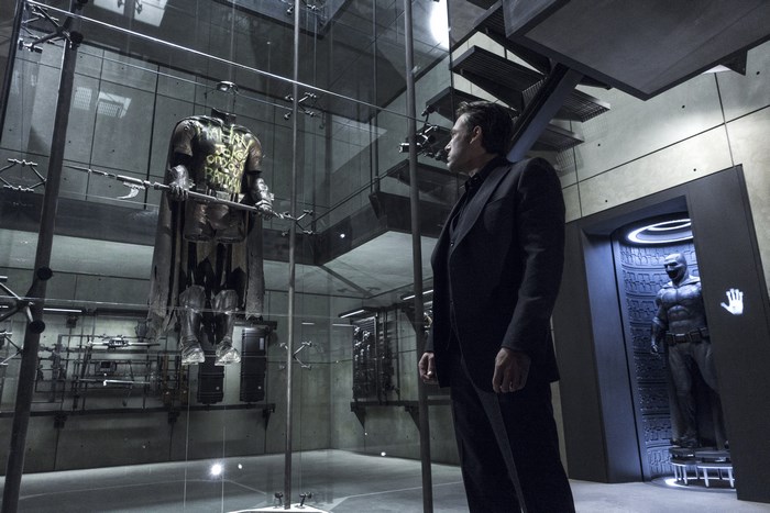 Bruce Wayne in the Batcave with Robin's suit and Batman