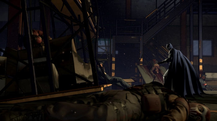 Batman in a dark room with injured people