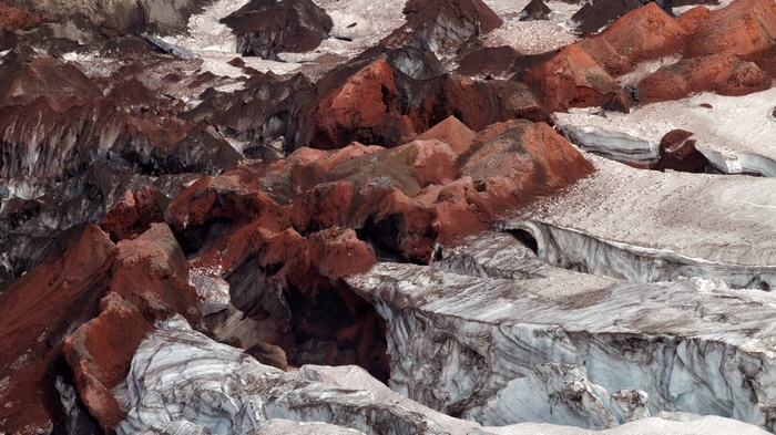 Red and brown mountains on a glacier