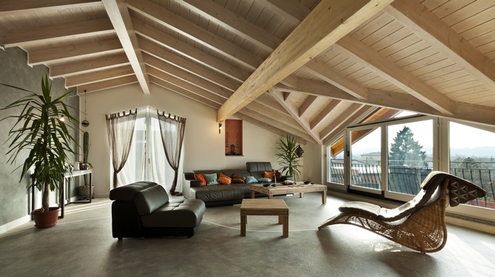 Attic living room with exposed beams and large windows