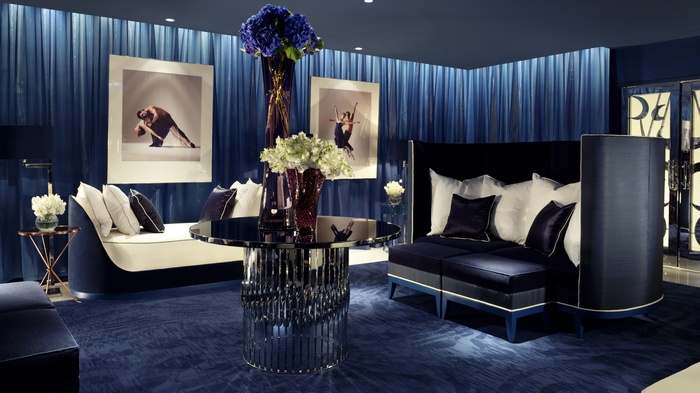Luxurious blue lounge with artwork and floral arrangements