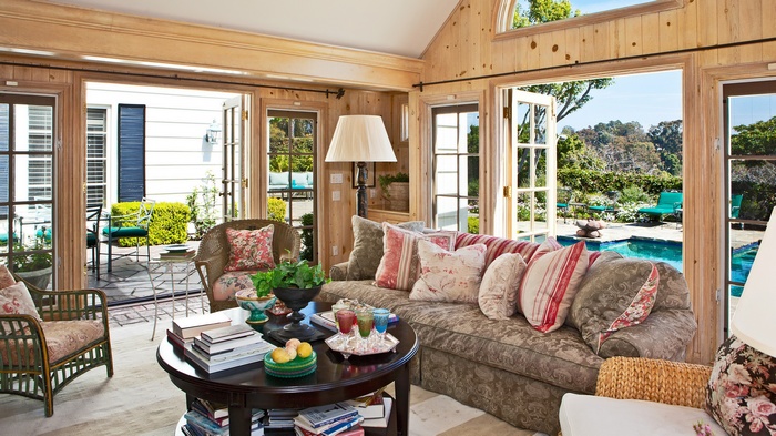 Living room with French doors opening to a pool and garden