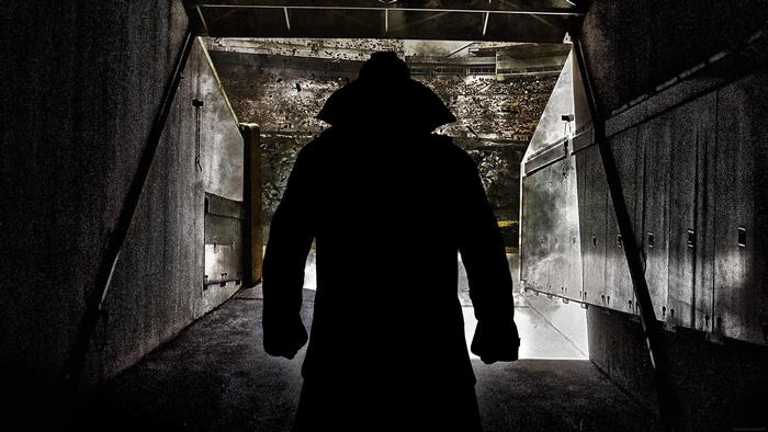 Silhouette of a person in a trench coat