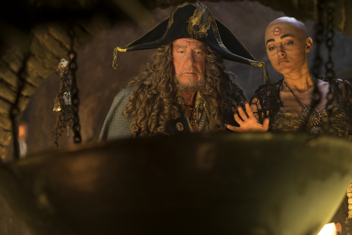 Hector Barbossa and a bald woman in a dark room