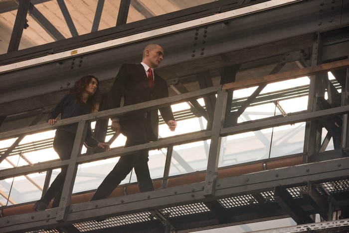 Agent 47 and woman on walkway