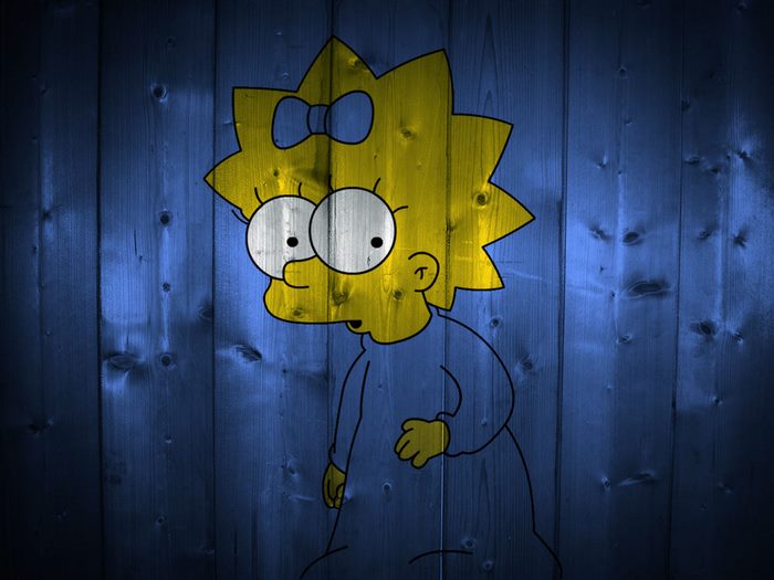 Maggie Simpson on blue wooden background