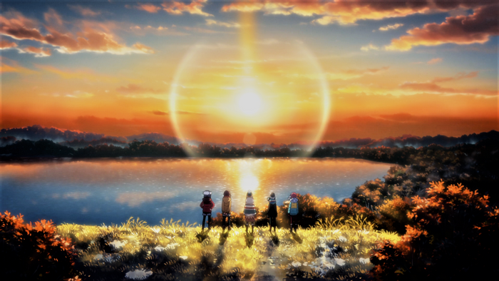 Group of girls watching a sunset over a lake