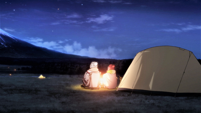 Two people camping at night with Mount Fuji in the background
