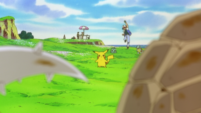 Ash Ketchum and Pokémon on a grassy field