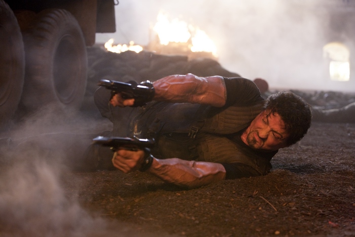 Barney Ross from The Expendables holding two guns