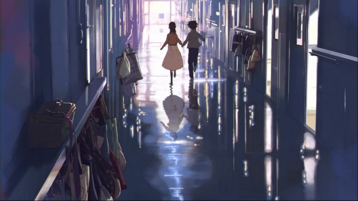 Two people walking down a school hallway