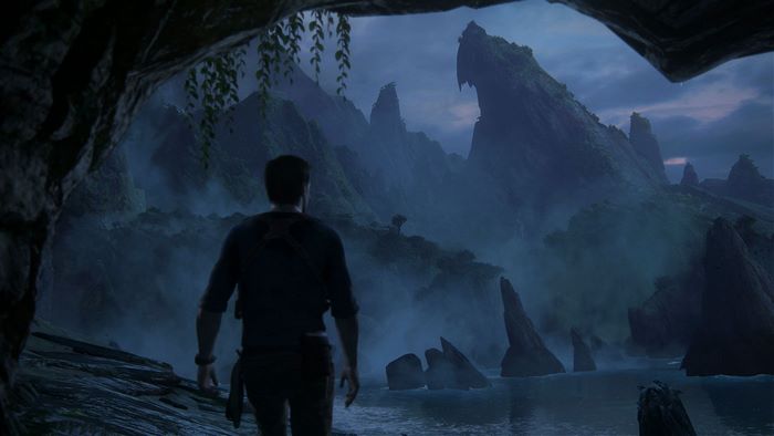 Nathan Drake in a cave overlooking a misty landscape