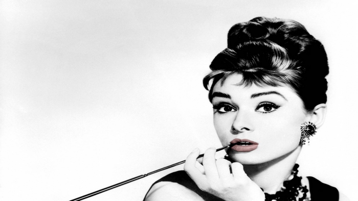 Audrey Hepburn applying lipstick