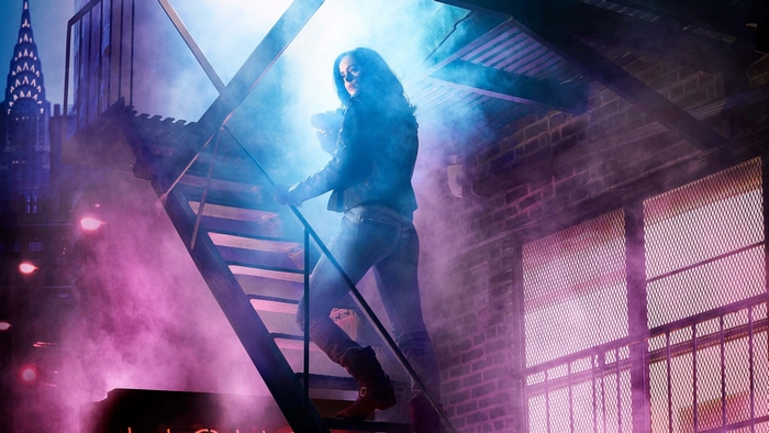 Jessica Jones on stairs with city background