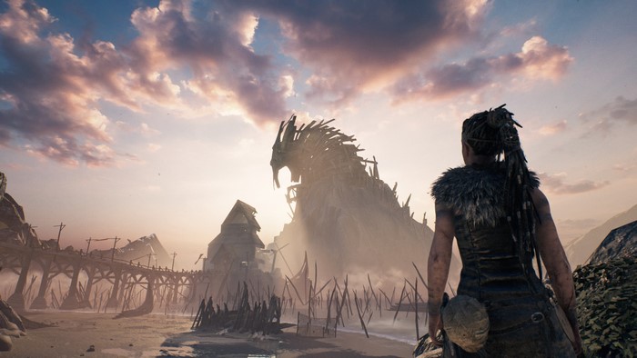 Senua from Hellblade looking at a wooden dragon structure