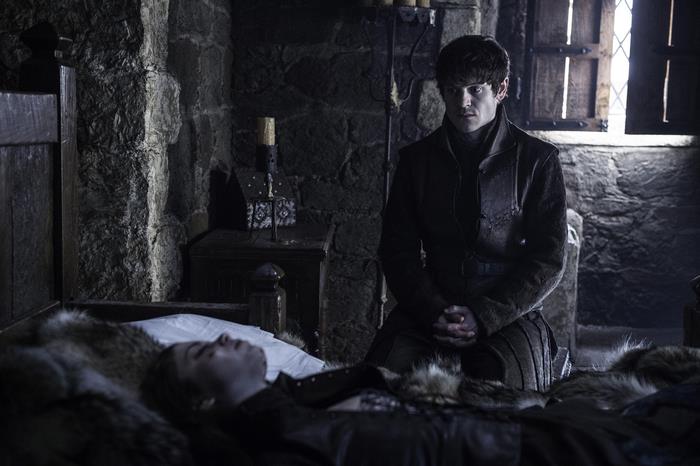 Ramsay Bolton kneeling by a person in bed