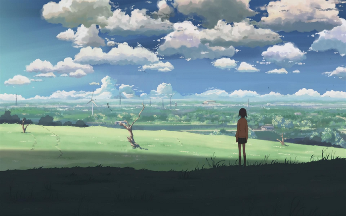 Akari Shinohara in a grassy field with wind turbines