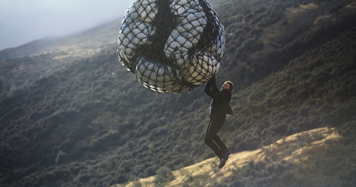 Ethan Hunt hanging from a large net of packages