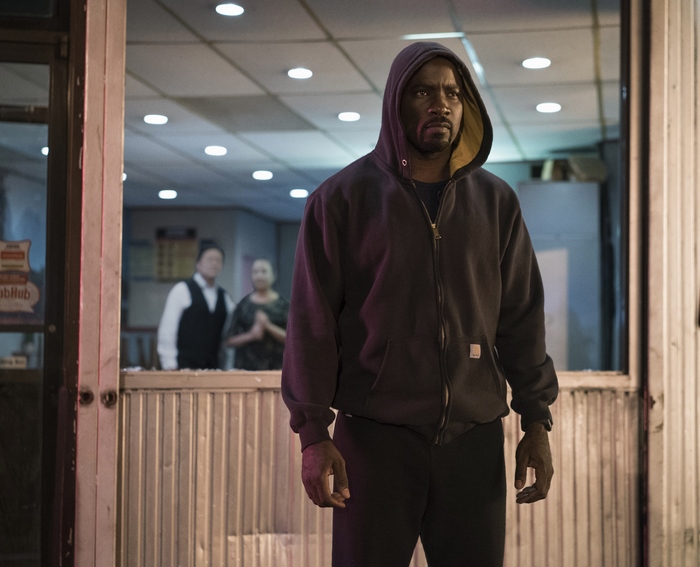 Luke Cage standing outside a store