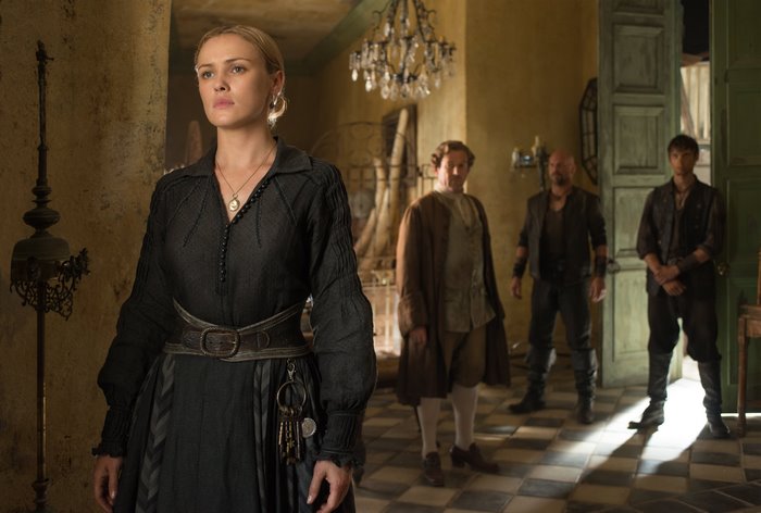 Eleanor Guthrie in a dark room with men