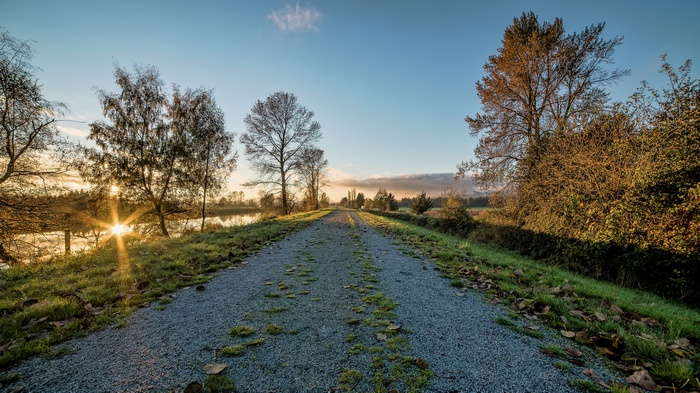 Gravel path along a lake at sunrise