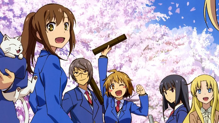 Group of students with a cat under cherry blossoms