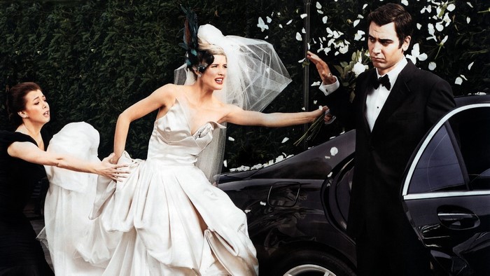 Bride and groom arguing by a car