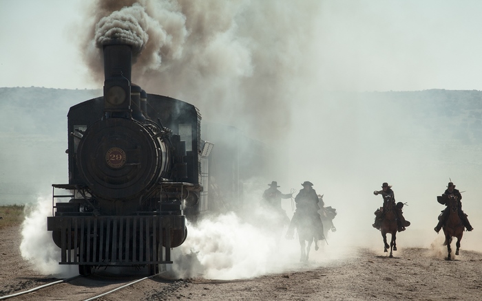 The Lone Ranger on horseback chasing a steam train