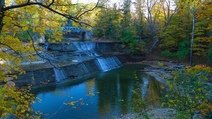 Waterfall and bridge in autumn forest