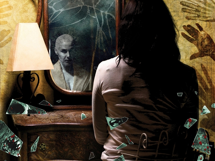 Pinhead from Hellraiser reflected in a broken mirror