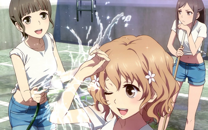 Three girls playing with a hose