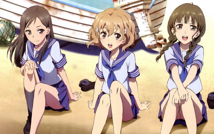 Three girls in sailor uniforms on a beach