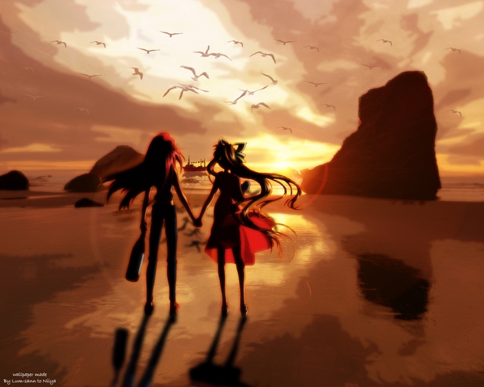 Two girls holding hands on a beach at sunset