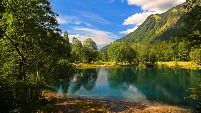 Turquoise lake surrounded by trees and mountains