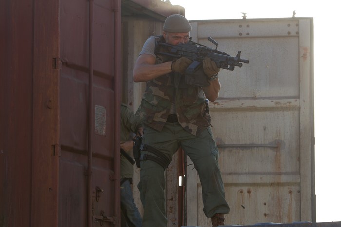 Man with machine gun in shipping container