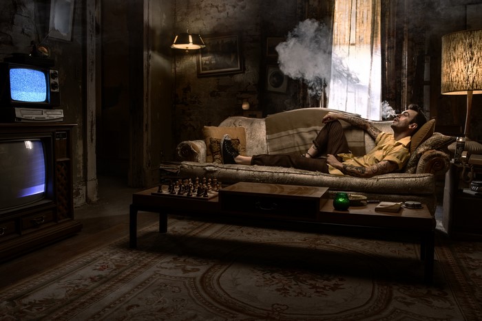 Cassidy from Preacher smoking on a couch