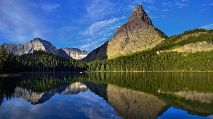 Mountain reflected in a calm lake with pine trees