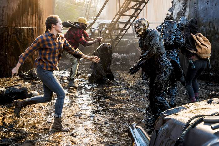 Alicia Clark and others in a muddy, destroyed area
