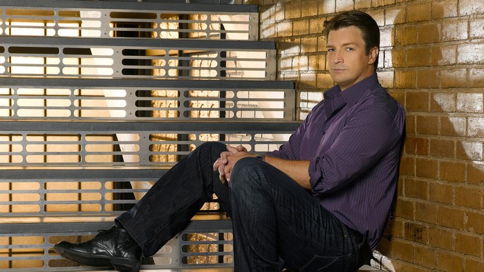Richard Castle sitting on stairs
