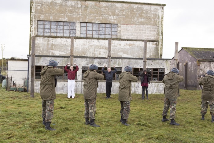 Frank Moses and hostages in front of a building