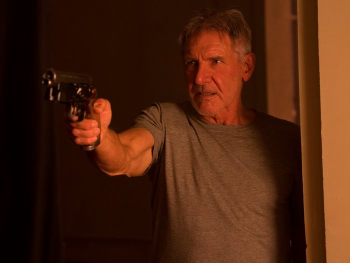 Rick Deckard from Blade Runner holding a gun