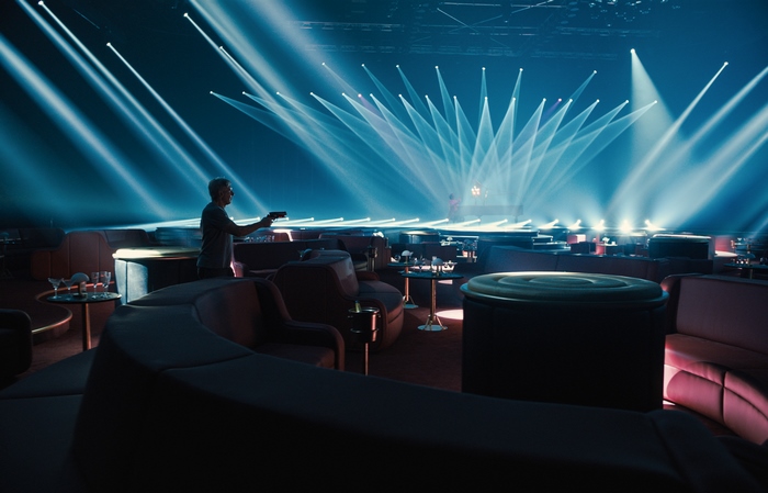 Rick Deckard holding a gun in a nightclub