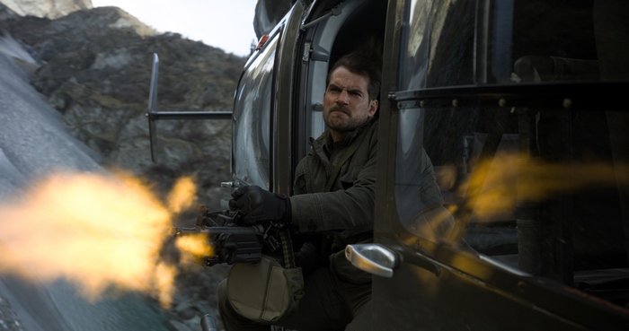 August Walker firing a machine gun from a helicopter