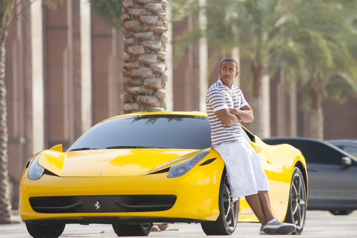 Man leaning on a yellow Ferrari