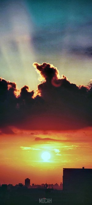 Sunset over city skyline with dramatic clouds