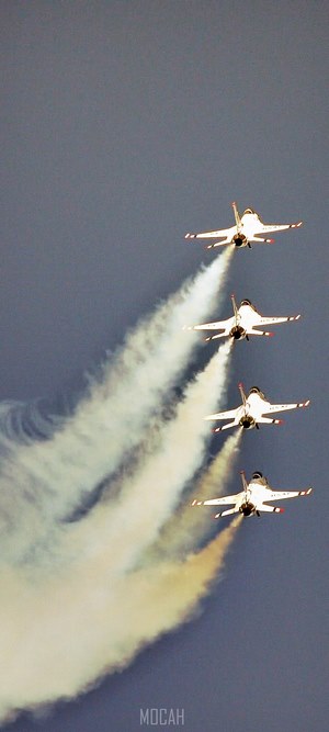 Four jets flying in formation with smoke trails