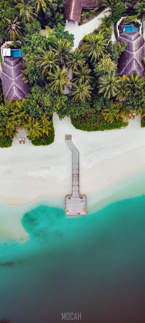 Aerial view of tropical resort with pier and turquoise water